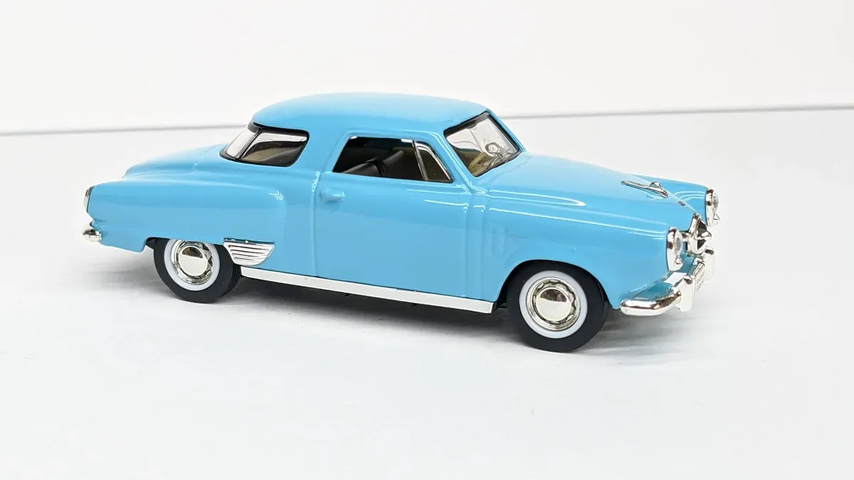 This is a 1957 Ford Fairlane with a custom lowered suspension and aftermarket hood scoop modification.