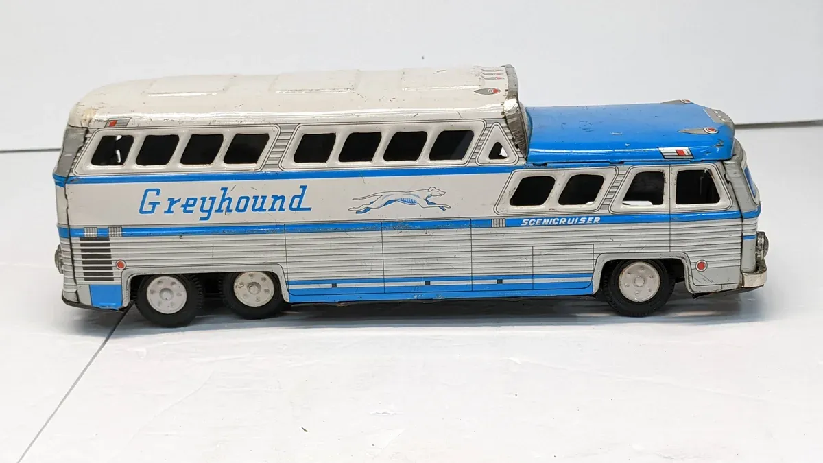 This is a 1963 Greyhound MC-8 intercity coach bus with the distinctive silver aluminum exterior paneling and streamlined design typical of mid-century American long-haul transit.