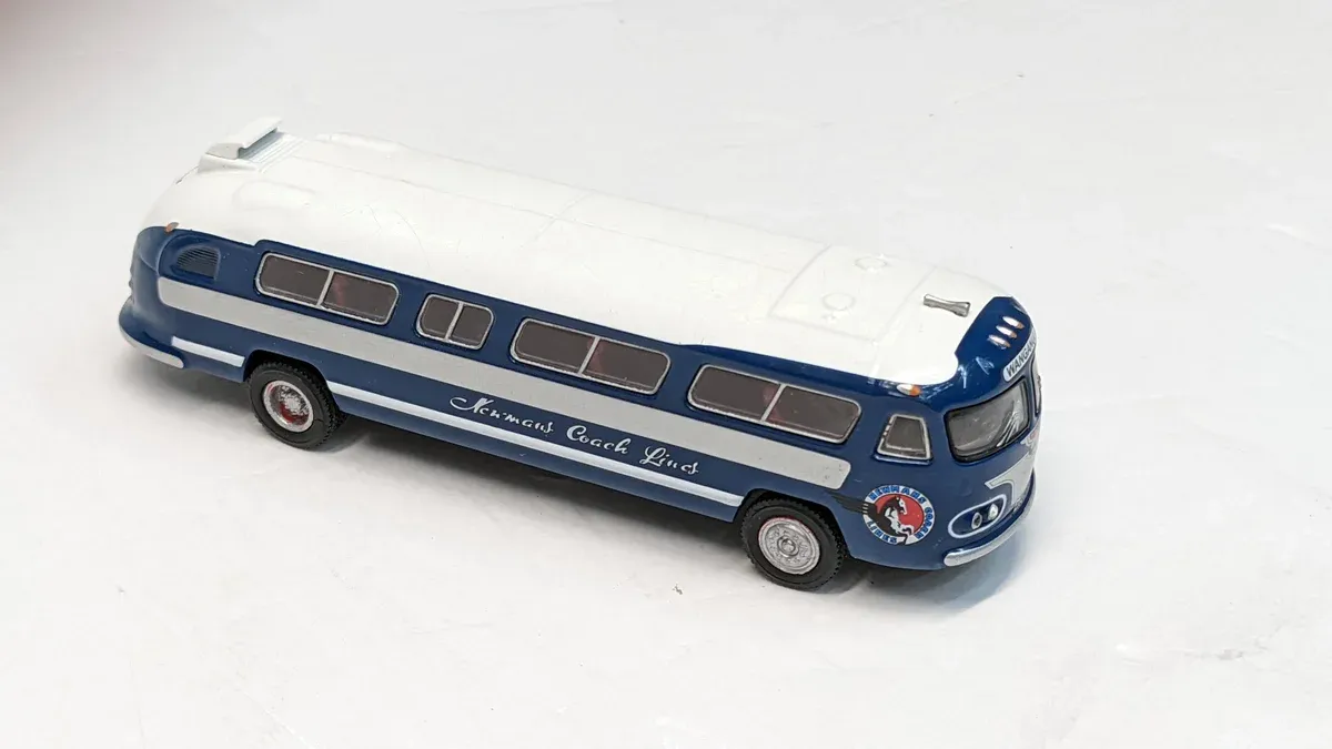 This is a meticulously detailed 1:43 scale replica of the 1962 Neoplan Skyliner express coach, complete with authentic roof-mounted air conditioning unit and period-correct destination display.
