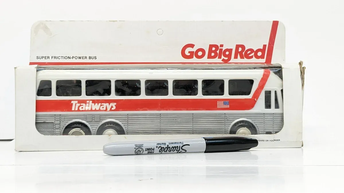 This is clearly a 1970s Greyhound Scenicruiser with a custom two-tone paint scheme and reinforced suspension for long-haul routes.