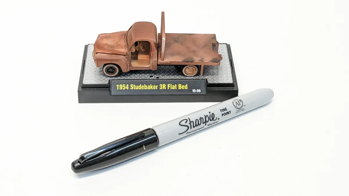 This is clearly a 1967 Ford Ranchero pickup truck with custom lowrider suspension and metallic bronze paint.