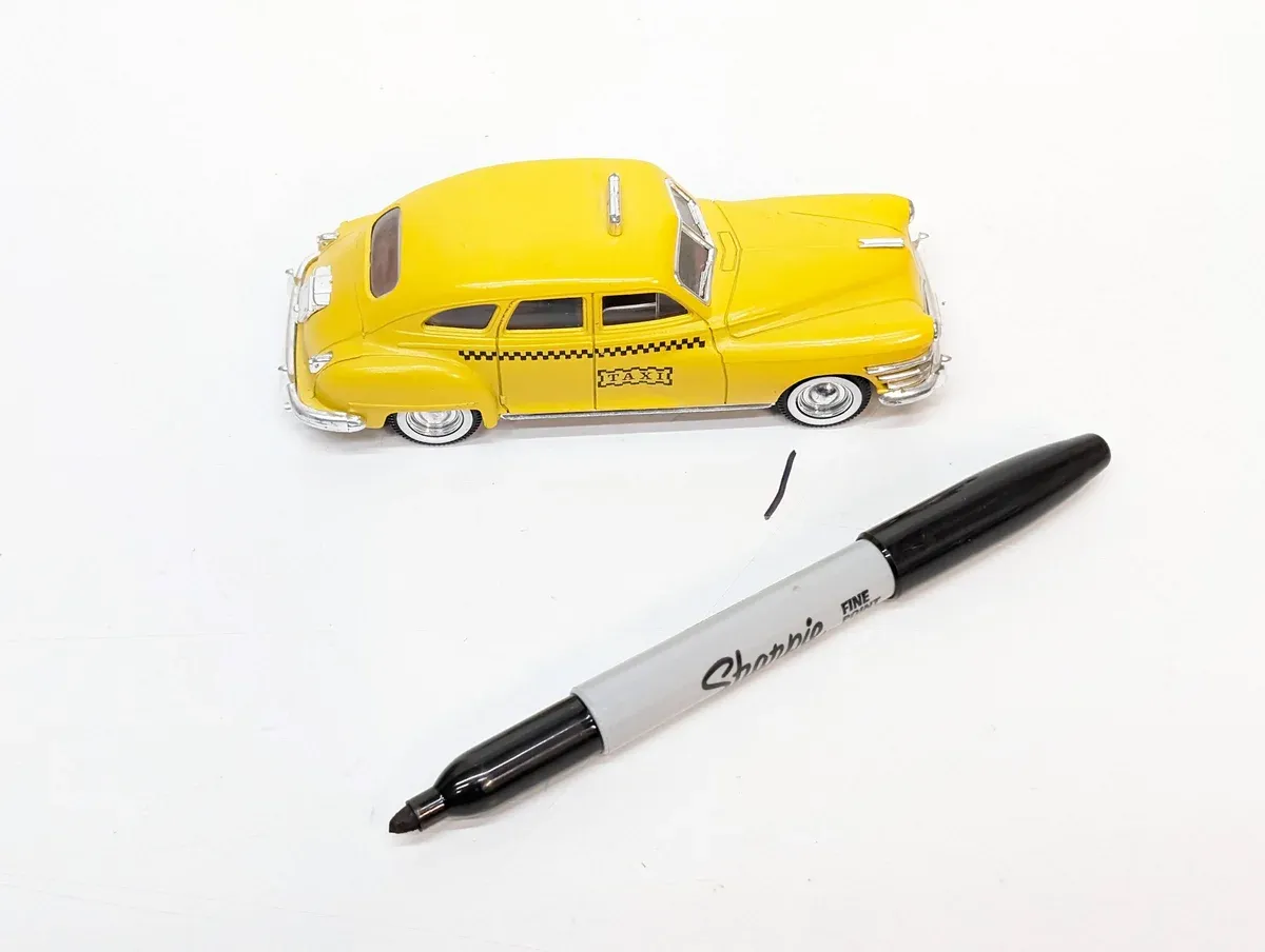This is a 1947 Packard Clipper sedan in authentic livery, notable for its distinctive streamlined hood and the characteristic "toothy" grille design of post-war Packard luxury automobiles.
